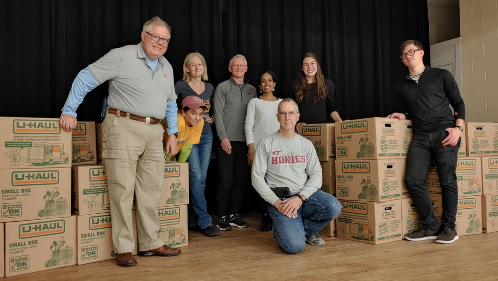 group photo of Our Lady of Lourdes volunteers with the food boxes they prepared for refugees
