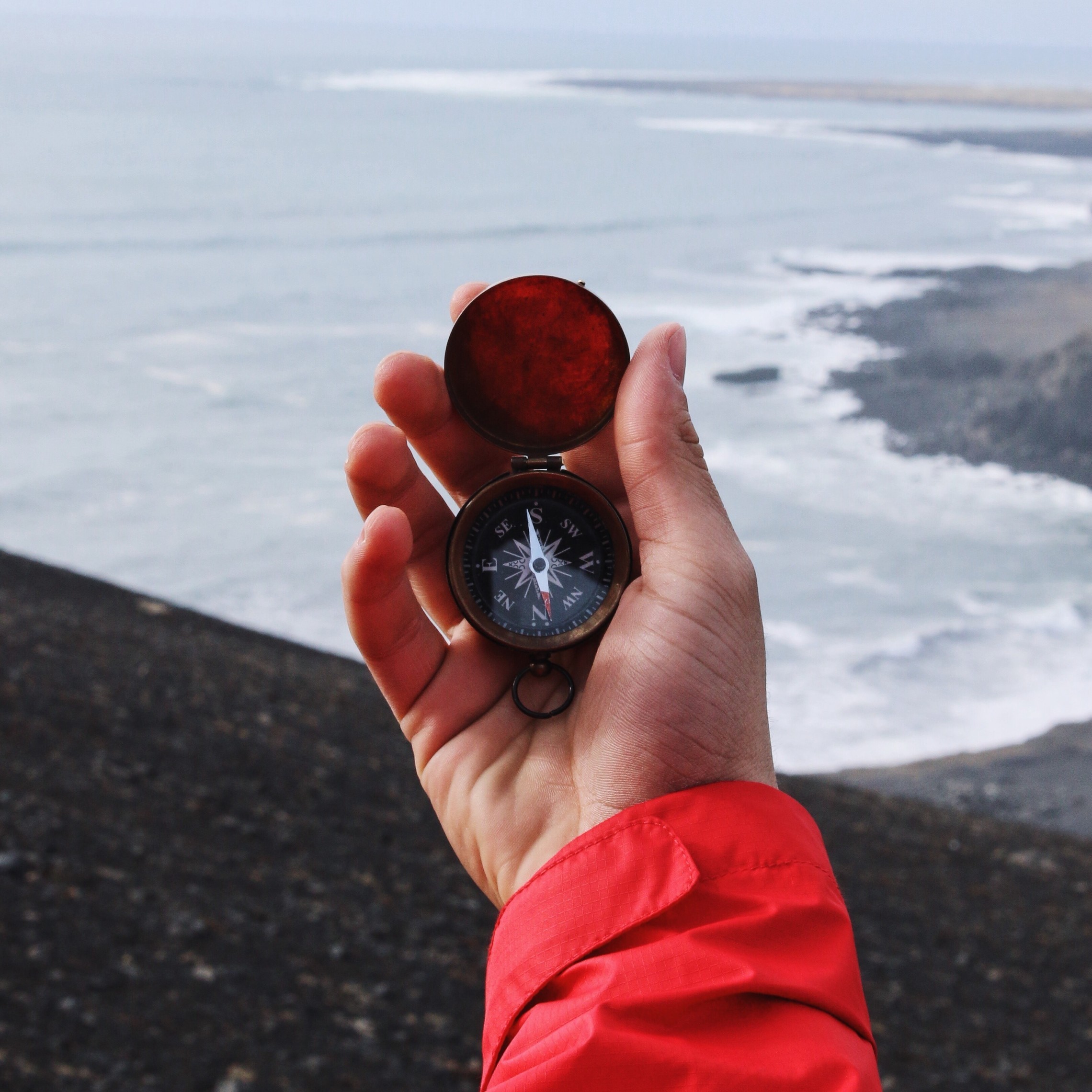 Holding a compass at the seashore