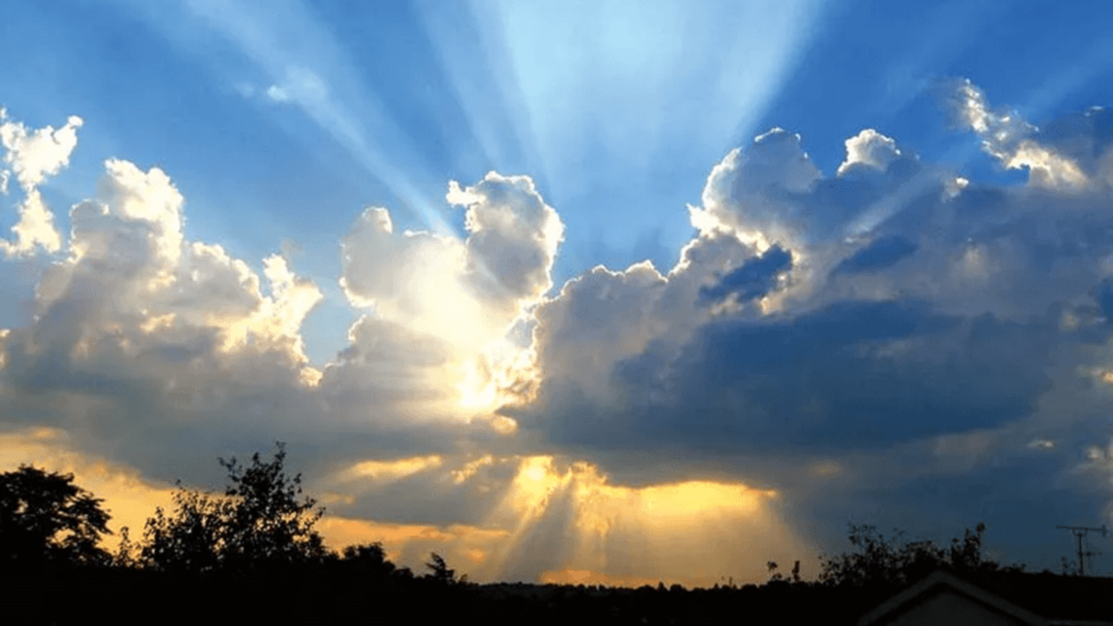 blue sky with sunlight breaking through the clouds