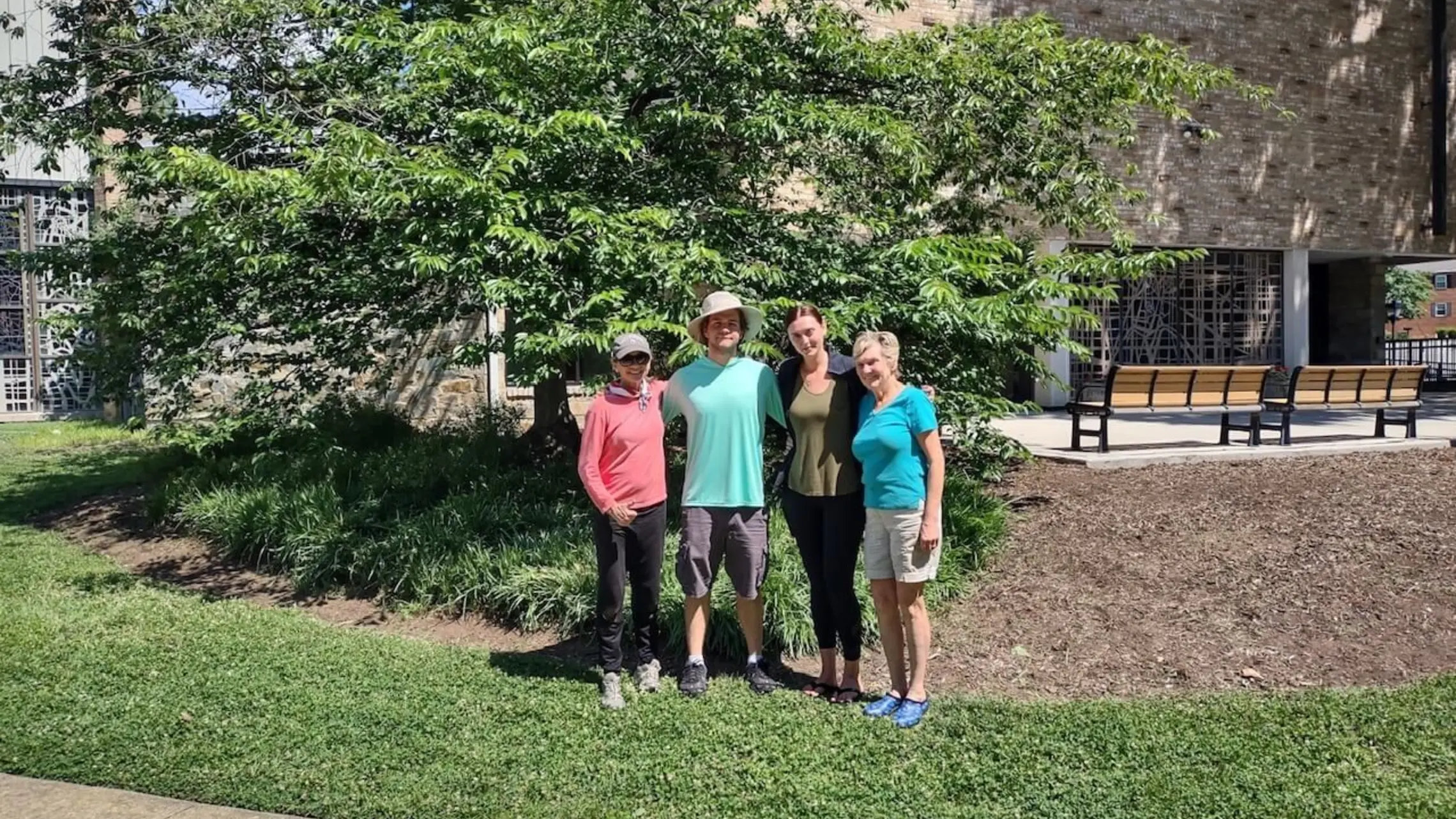group photo of people underneath a tree in front of the church