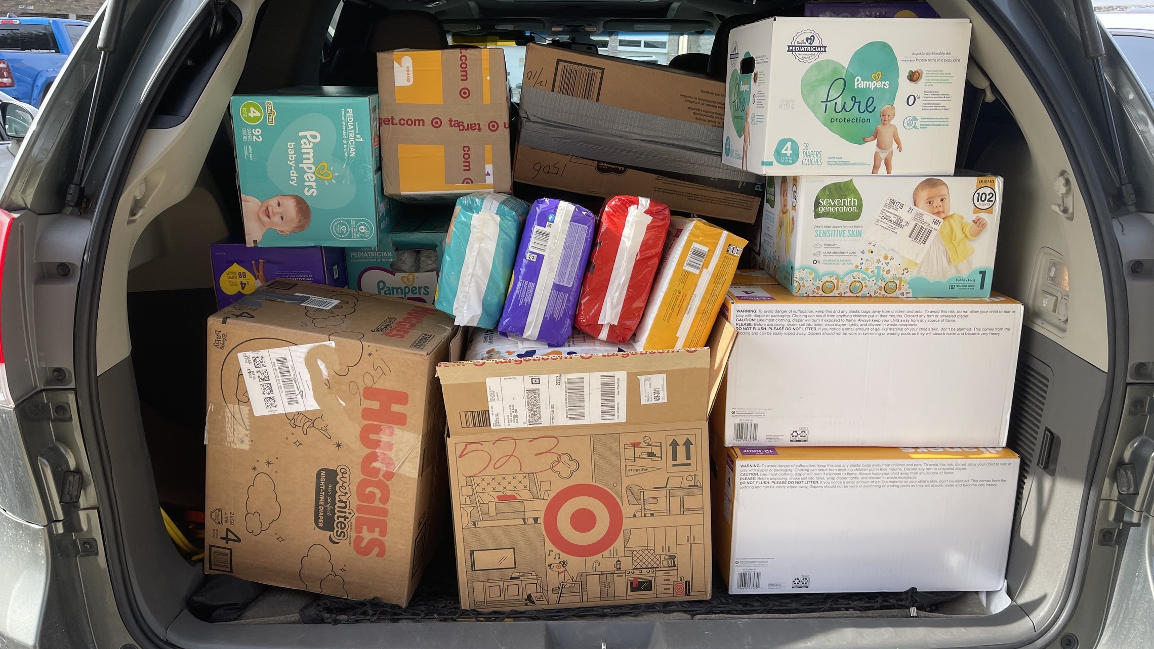 photo of an open SUV trunk with diapers and baby supplies packed in