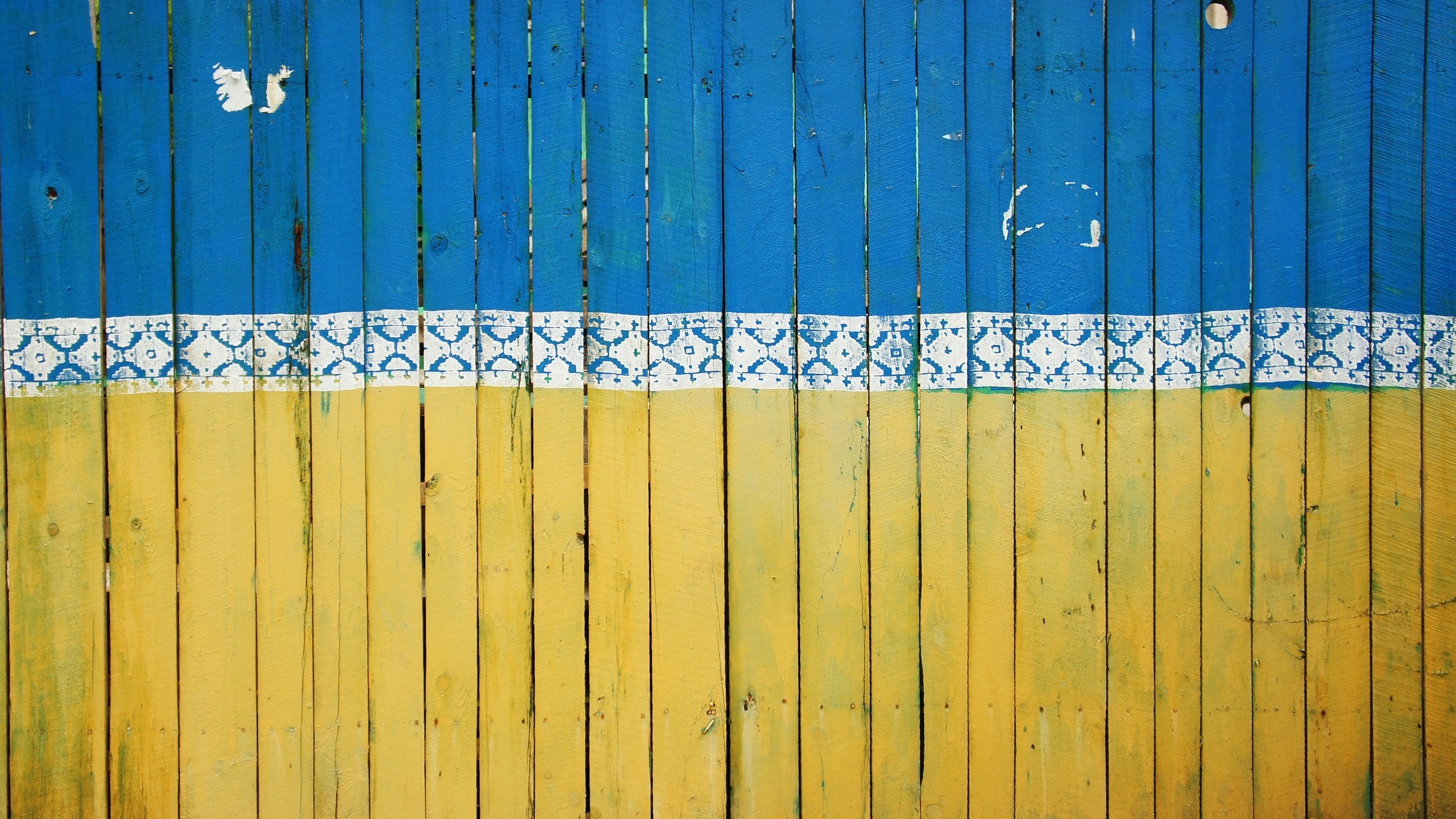 wooden fence painted in the Ukrainian flag colors