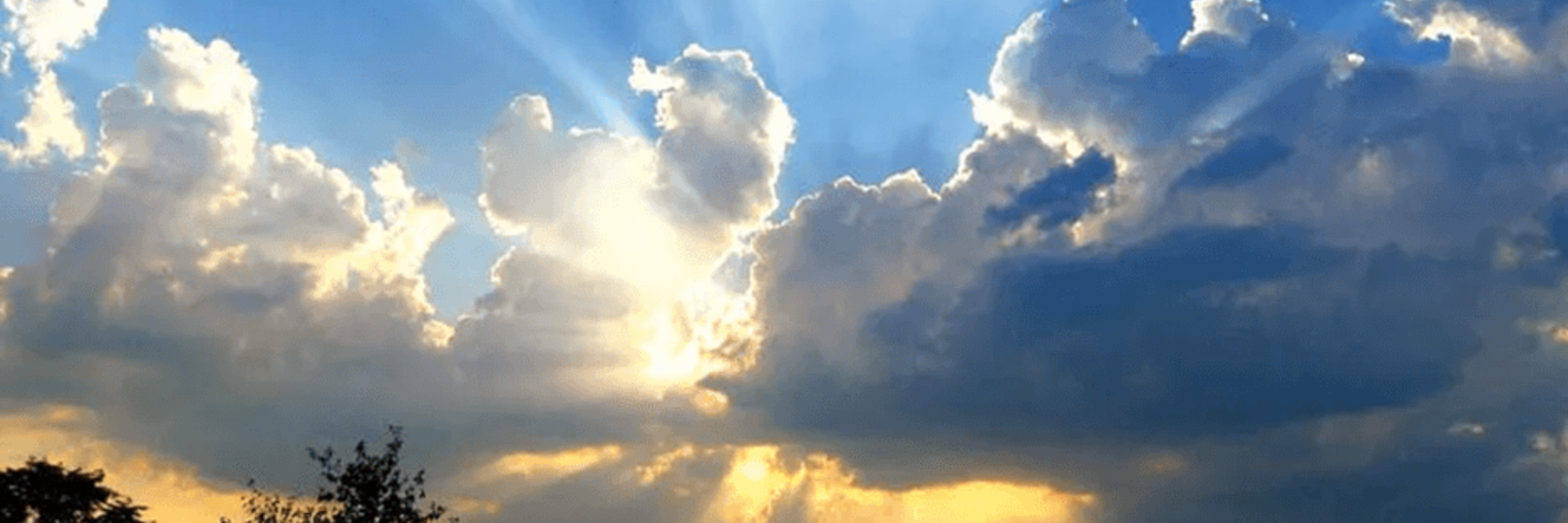blue sky with sunlight breaking through the clouds
