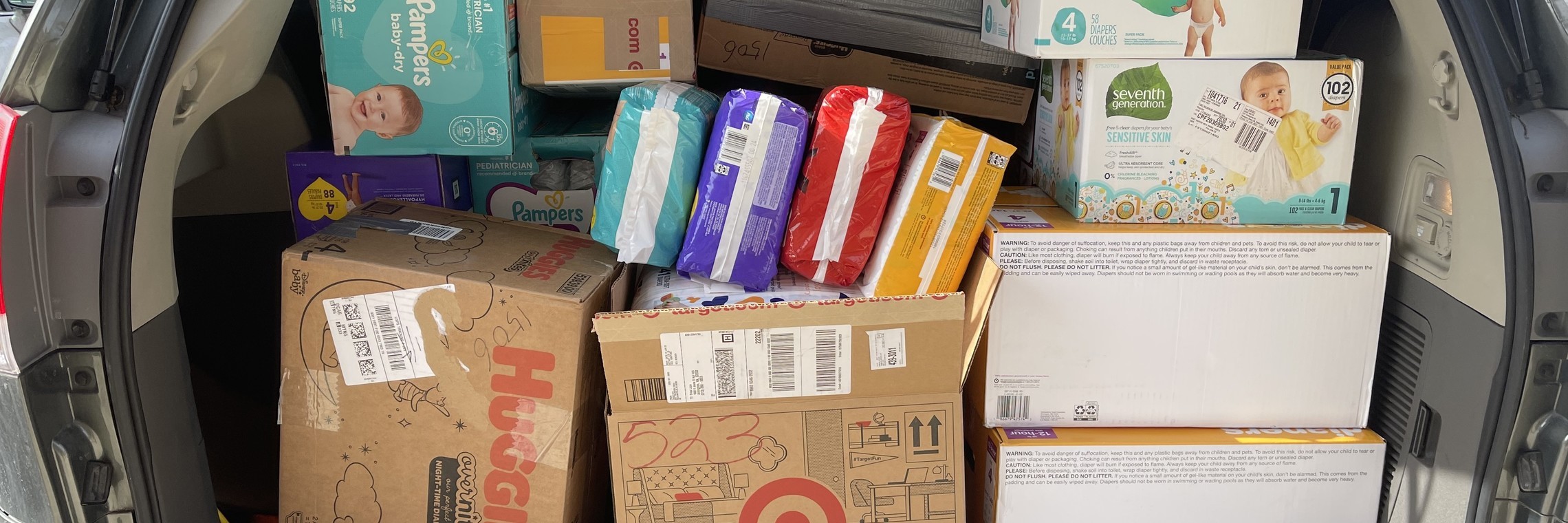 photo of an open SUV trunk with diapers and baby supplies packed in